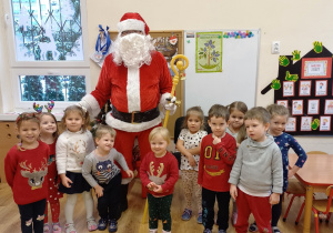 Dzieci pozują do zdjęcia z Mikołajem.